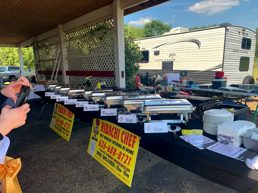 Hibachi food stations with multiple proteins at catered event